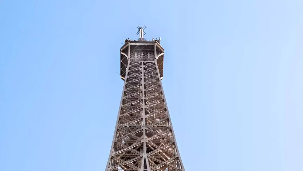 Sommet de la Tour Eiffel avec zoom sur l'antenne permettant d'émettre le signal TV TNt à Paris